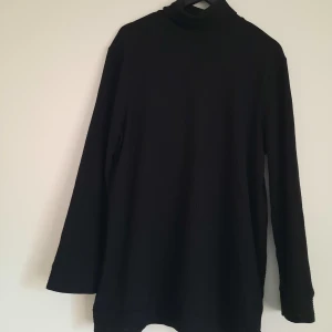 Oversize polotröja NA-KD - Svart polotröja i längre oversize-modell från NA-KD. Mycket fint skick. 