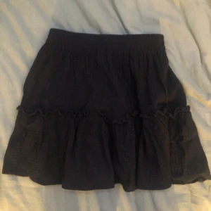 svart kjol - svart fladdrig sommarkjol med en volang. använt max 2 gånger så den är som ny. jättesöt till sommaren. säljer för den inte kommer till användning 💗skriv för fler bilder eller om ni har nån fråga 