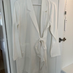 Vit omlottklänning i linne - Vit omlottklänning i linnematerial, oanvänd endast provad