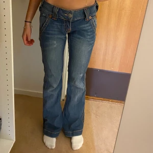 True religion jeans - As snygga lågmidjade utsvängda true religion jeans. Dom är mörkblå och i storlek 28. Jag är 167