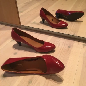 Röda lackade klackskor - Små röda klackar med lite ormskinnsliknande möster och svart/mörkbrun klack. 