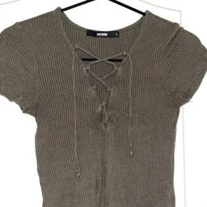 Militär grön tröja med snörning  - Militär grön ribbad tröja med snörning från bikbok i storlek S.