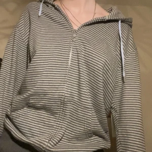 Randig tjocktröja - En grå randig zip up med ljusblåa detaljer <3