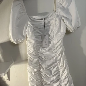 Vit klänning - Superfin vit klänning som skulle vara perfekt till studenten eller andra fina tillfällen i sommar💘 HELT NY! Nypris 499kr. Slutsåld i alla storlekar!  För liten för mig därför säljer jag vidare den. Säljer en till vit klänning, kolla min profil 🫶