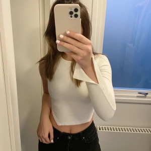 NA-KD topp - En jättefin vit topp med en ärm och en speciell öppen rygg med knytning. Från Angelica Blicks kollektion med NA-KD.💗