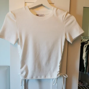 Vi tröja - Oanvänd. Vi tröja med detaljer vid sidan. 