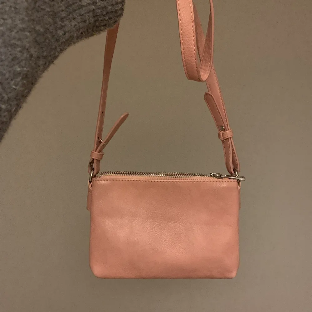 Säljer min rosa crossbodybag! Har haft den i några år med den är knappt använd❤️ Den har två fack med dragkedjor och justerbart band!. Väskor.