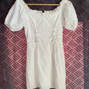 Studentklänning  - Vit student/avslutningsklänning, ”korsett” liknande detalj i midjan som man kan dra åt något, off shoulder💗använd 1 gång, storlek 34, skulle säga mer 34/36🤭