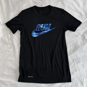 Träningstopp - Skön tröja att träna i från Nike med coolt tryck i blått. T-shirt modell, går att använda till vardags. Bra skick!