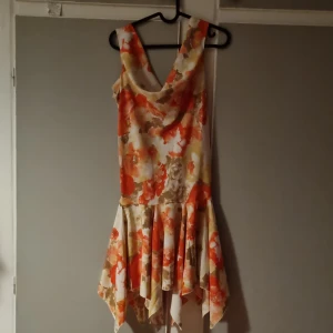 Festlig färglad klänning - Fin festlig klänning med som tyvärr inte längre passar mig. Fina orangea och vita färgersom verkligen framhäver blåa ögon så starkt tips om man har det!! <3