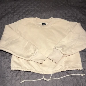 Mjuk beige justerbar sweatshirt - Oanvänd beige justerbar sweatshirt i storlek xs men passar även S