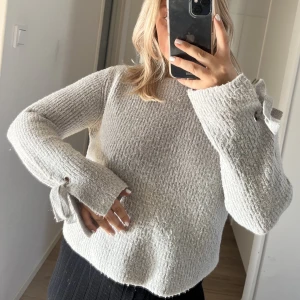 Stickad tröja  - Grå stickad tröja från Mango med fina detaljer vid armen i storlek S. 