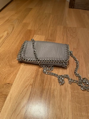 Tiamo väska  - Den har jättebra skick! Och har typ använt den några gånger typ 3. Den är jättefin 💕🤗den är typ grå,beige Max 250 inte mindre än det! 