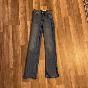Jeans - Blåa jeans med slits längst ner. Dem är från Gina Tricot och heter ”Molly”. Jeansen är i storlek xxs.