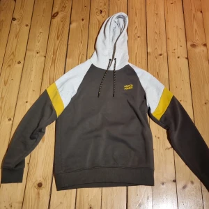 Ögledtickad Sweatsydd Hoodie - Hoodie från Jack & Jones (tillhörande byxor säljs i annan anonns). Bild 3 föreställer båda plaggen tillsammans.  Använd enstaka gång, nyskick. Hoodien inköpt för 400 kr. 
