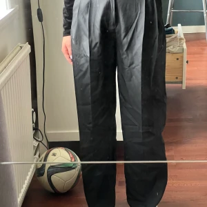 Kostym byxor - Super härliga kostymbyxor i ett litet glansigt material med hög midja. Jag är 163cm lång och storleken är 34