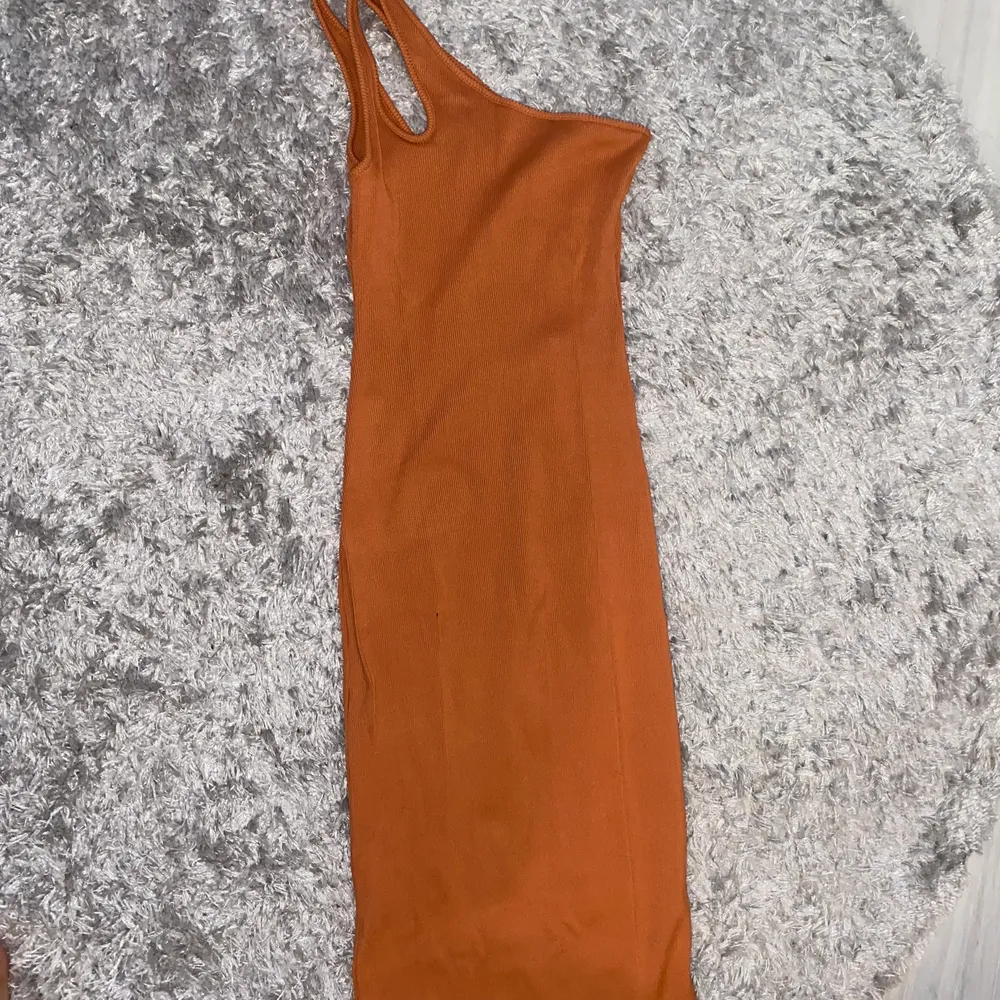 Snygg orange one shoulder klänning som är knälång. Väldigt bra skick. . Klänningar.