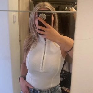 Vit topp  - Topp från Nelly trend i storlek S  Sjusterbar dragkedja.