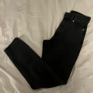 Mom jeans från monki i sliten svart färg (de ska vara så). Storlek W24, ankellånga. Använda och en ögla är trasig (se bild 3) men det påverkar inte funktionen. 