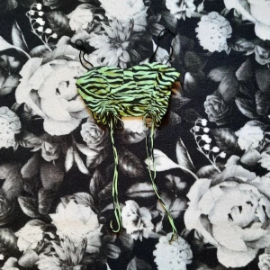 Grön partytopp - Säljer grön croptopp med justerbar längd vid magen och grönt "zebramönster". Det för att den inte kommer till användning. Det kan vara svårt att se på bilderna men den har svarta, tunna axelband. Den är tunn i tyget och passar perfekt nu till sommaren. Linnet är i toppskick och är använd 1 gång. OBS! banden är lite fållade men sitter mycket bra fast. Frakten är inte gratis utan förhandlas. Kolla mina villkor i min bio först. Om du har funderingar hör av dig!