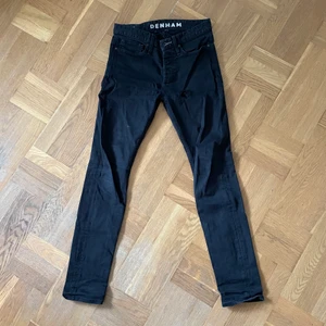 Denham svarta jeans 29  - Svarta jeans från denham som har ett litet hål på vänster ben upptill. Utöver det mycket fina! Storlek 29