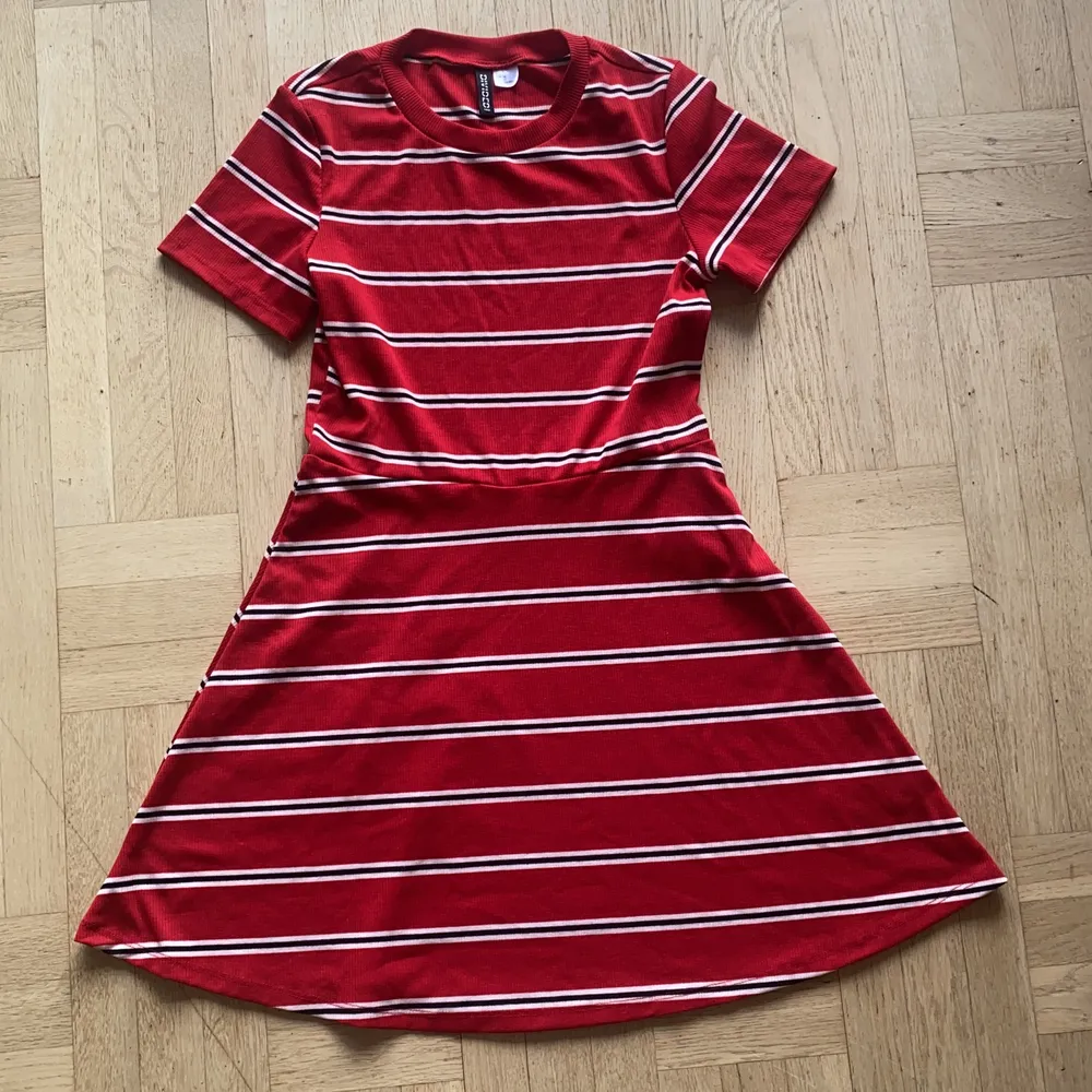 Röd, svart och vit-randig kort klänning med korta ärmar. Räfflat tyg. Aldrig använd, nyskick. Från divided by HM. . Klänningar.