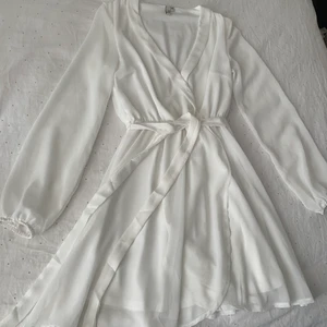 Vit klänning  - Super fin klänning från Nelly med knytning i midjan, knappt använd. Storlek XS 