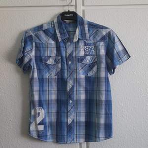 Blå rutig skjorta i storlek 146/152 från Lindex. Utmärkt skick, använd fåtal gånger. 