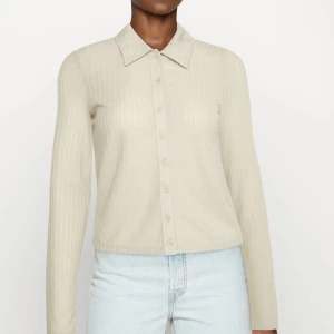 Tunn skjorta - Fint typ skjort/blus i mjukt material.  Beige.  Strl XL - passar M beroende på hur man vill att den ska sitta.  Använd fåtal gånger. 