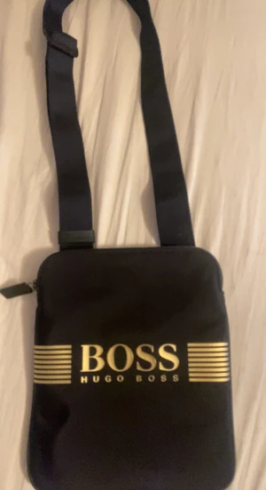 Hugo boss axelväska - Helt ny hugo boss axel väska Fraktas samma dag. Helt oanvänd och har bara legat hemma. Skick:10/10 Nypris 1300ca