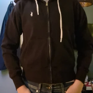 Svart Ralph Lauren Hoodie - En fet ralph lauren hoodie som knappt har använts. Jag har storlek S och den passade mig fast den var lite tight och jag är 180. Den passar perfekt på XS och mindre. Nypris är 2200.