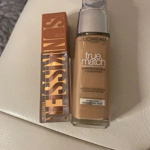 Foundation och rouge från L'Oréal och Maybelline - Säljer en L'Oréal Paris True Match foundation med hyaluronsyra för återfuktning och en Maybelline Cheek Heat blush i en varm ton. Perfekt för en jämn och naturlig look.