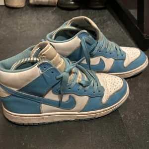 Nike Dunk i blått och vitt  - Snygga Nike Dunk sneakers i blått och vitt. Skorna e i storlek 39 och e lite slitna men de finns inga hål i skorna.