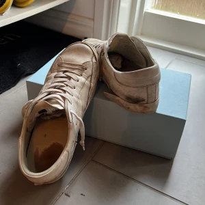 Vita sneakers från Philippe Model - Säljer ett par vita sneakers från Philippe Model. Skorna har snörning och en klassisk design med en svart sula. Perfekta för en avslappnad stil. Många defekter behöver rejäl tvätt.