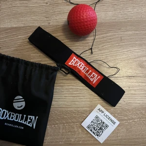 Boxboll med pannband från Boxbollen - Träningsset med en röd boxboll och ett svart pannband med Boxbollen-logga. Perfekt för reflex- och koordinationsträning. Super roligt att tävla mot familjen 