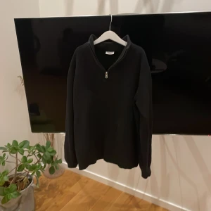 Half zip - Säljer en svart half zip tröja från Kappahl med dragkedja vid halsen. Tröjan har långa ärmar och en hög krage, perfekt för kyligare dagar. Enkel och stilren design som passar till det mesta.