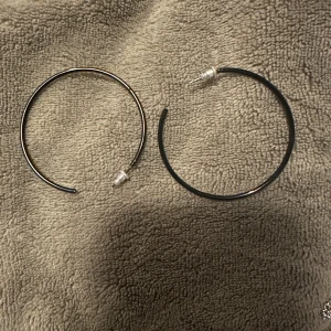 Svarta örhängen i metall - Säljer ett par stilrena svarta örhängen i metall. De är runda och har en enkel design som passar till många olika stilar. Perfekta för både vardag och fest.