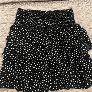 Svart prickig kjol med volanger - Trendig svart kjol med vita prickar och volanger. Perfekt för sommaren🌸💗Kjolen är från Mango Kids i storlek 13-14 år, men passar perfekt för mig som är 167 cm 