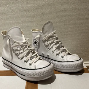 Vita höga sneakers från Converse - Säljer ett par klassiska vita höga sneakers från Converse med snörning och den ikoniska All Star-loggan på sidan. Size 38 och väldigt bra skick. Nypris ligger på 1200:- jag säljer dem för endast 699:- först till kvarn.