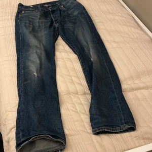 Levis 501 jeans - Säljer ett par klassiska Levis 501 jeans i blå denim. De har en straight passform och är lågmidjade. Perfekta för en avslappnad stil.