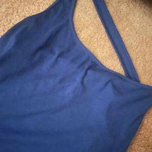 Blå ribbad linnetopp - Snygg blå ribbad linnetopp med smala axelband. Perfekt för varma sommardagar eller som ett lager under en jacka. Enkel och stilren design som passar till det mesta.