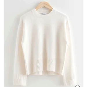 Vit stickad tröja - Säljer en stilren vit stickad tröja med rund hals och långa ärmar. Perfekt för kyligare dagar och enkel att matcha med olika outfits. Köpt frå &oterstories💓💓