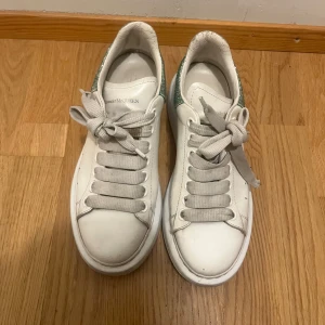 Alexander McQueen Sneakers - Alexander McQueen sneakers in white with a turquoise glitter backround. Good condition, a little flaw on the left laces.💞