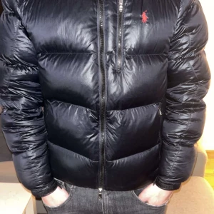 Svart dunjacka från Polo Ralph Lauren - Säljer en svart dunjacka från Polo Ralph Lauren i bra skick, 8/10. Storlek L