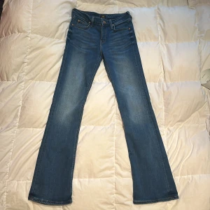 Blå bootcut jeans från Lee - Säljer ett par klassiska blå bootcut jeans från Lee. De har en snygg högmidjad passform och är tillverkade i slitstarkt denim. 