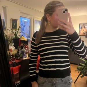 Svart och vit randig tröja från Vero Moda - Säljer en snygg svart och vit randig tröja från Vero Moda. Tröjan har långa ärmar och en klassisk rund halsringning. Perfekt för en stilren look.