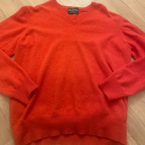 Alan Paine V-neck - Säljer en snygg röd tröja från Alan Paine i 100% Geelong lammull. Tröjan har en klassisk v-ringning och långa ärmar, perfekt för kyligare dagar. Den är mjuk och bekväm, idealisk för både vardag och mer uppklädda tillfällen.                          -Oanvänd.                                                                      -Kan även bäras av kvinnor, herrmodell 