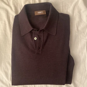 Mörkbrun pikétröja från Ströms - Snygg mörkbrun pikétröja från Ströms med klassisk krage och pärl knappar framtill. Perfekt för en stilren och fin look. Storleken på tröjan är medium och är true to size. Har endast använts ett fåtal gånger. Nypris ligger på 1799kr. 