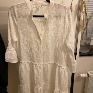 Vit klänning från New yorker - Säljer en luftig vit klänning från Amisu/new yorker i storlek EU 34. Klänningen har trekvartsärmar och volangdetaljer. Den är bara använd en gång. Den är medel lång. 