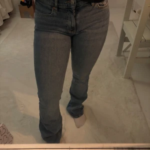 Blå jeans  - Snygga blå jeans med låg midja. Perfekta för en avslappnad stil. De har en knappgylf och femficksdesign.